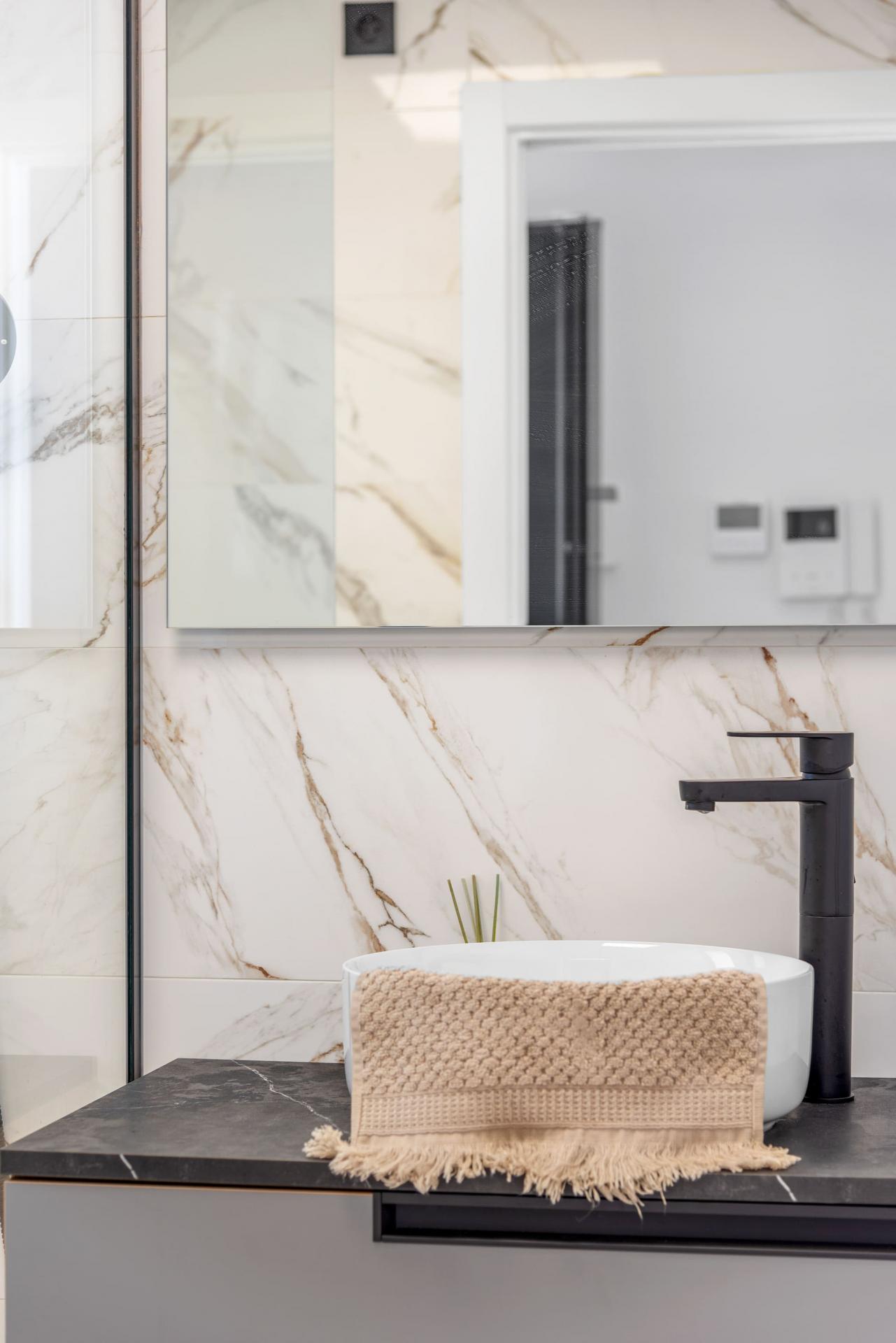 Bathroom with shower enclosure and tiled walls in El Raso new-build apartment