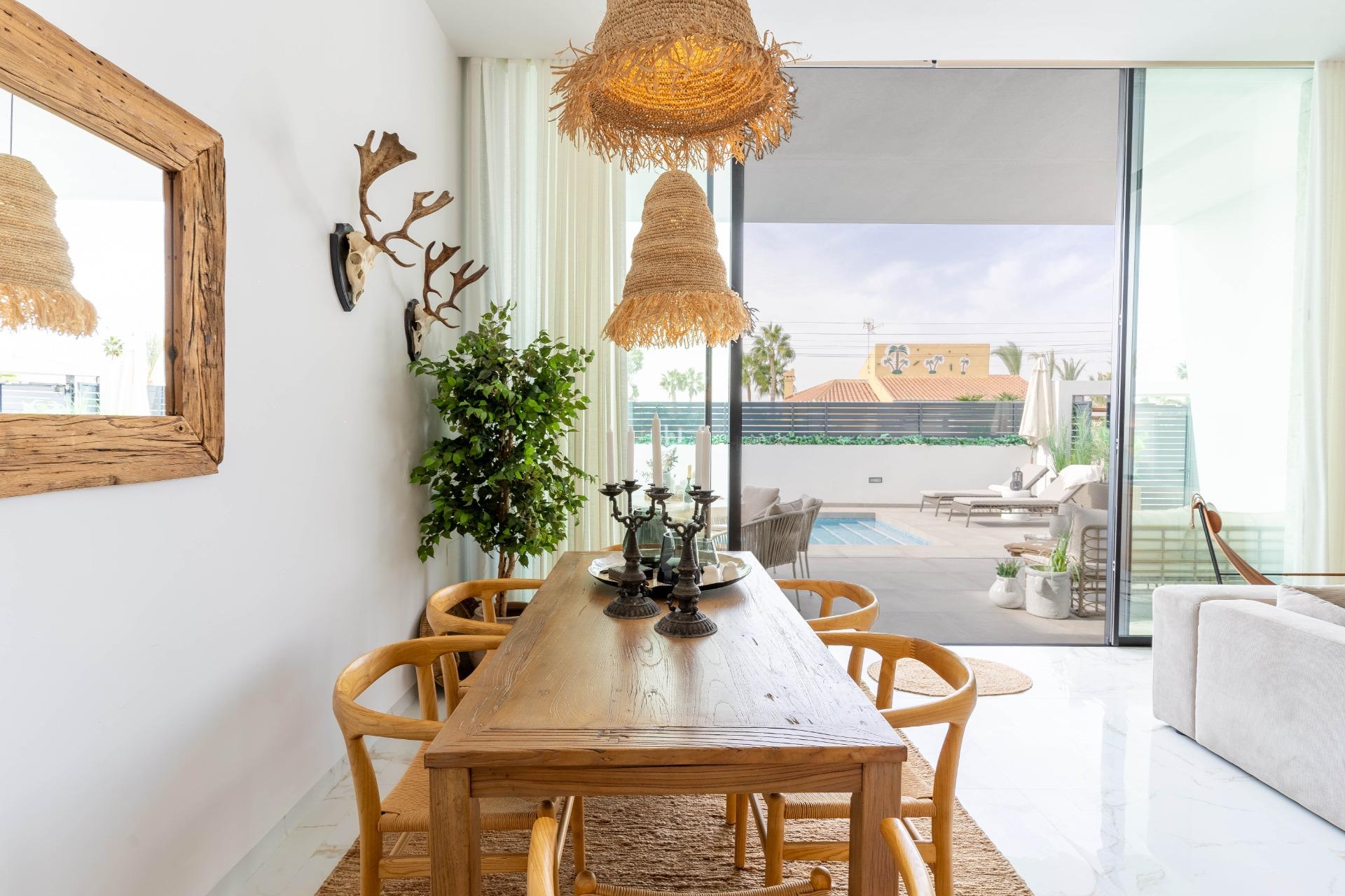 Dining table and chairs within open-plan living space, La Siesta villa