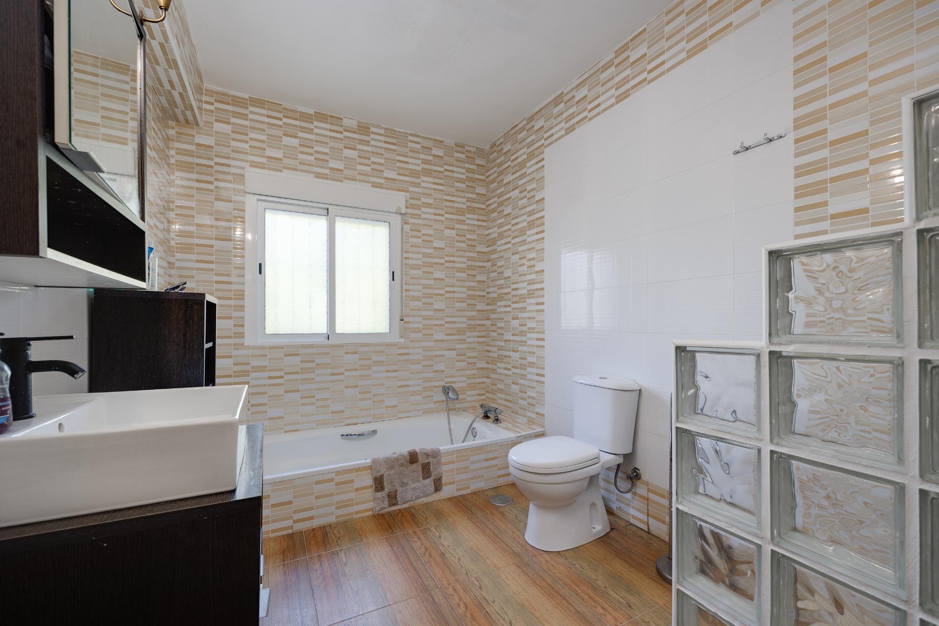 Main bathroom with full suite and tiled walls